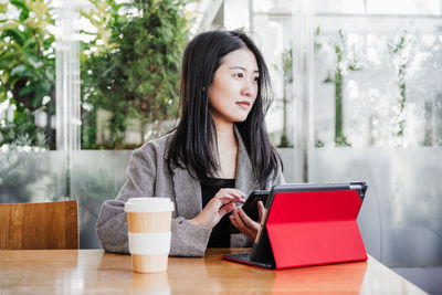 Professional chinese entrepreneur woman working on laptop in cafeteria. technology, lifestyle