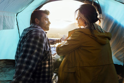 Couple spending vacation sitting in tent