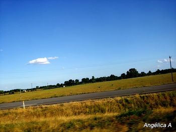 Scenic view of field against blue sky