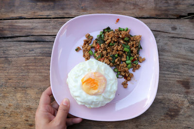 High angle view of person holding breakfast served on table