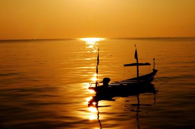 Silhouette of boat in sea at sunset