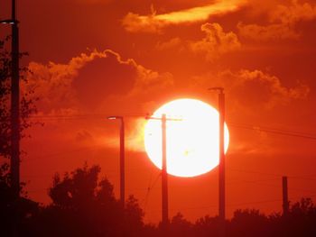 Silhouette street light against orange sky during sunset