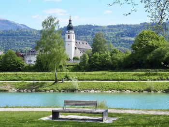 Park bench by building against sky