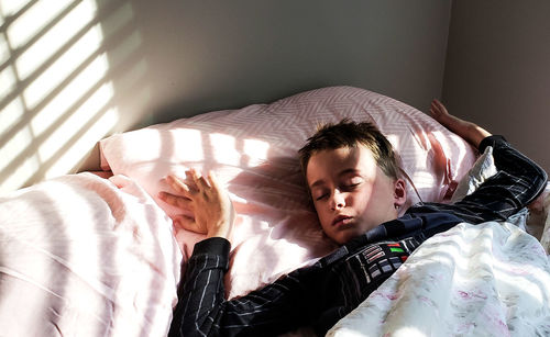 High angle view of boy sleeping on bed at home