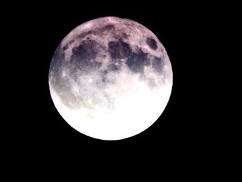 Low angle view of full moon against clear sky at night