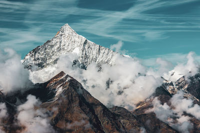 Scenic view of sea and snowcapped mountains against sky