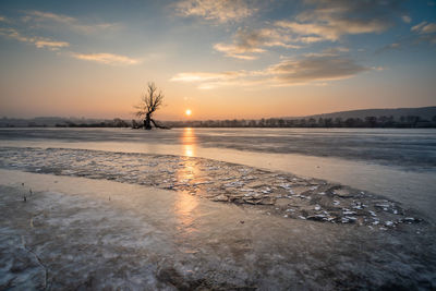 Scenic view of frozen sea against sky during sunset