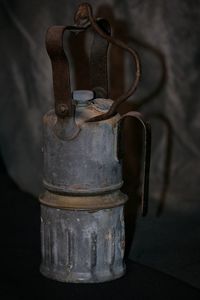 Close-up of rusty metal on table against wall