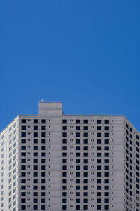 Low angle view of modern building against clear blue sky