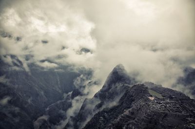 Scenic view of mountains against cloudy sky