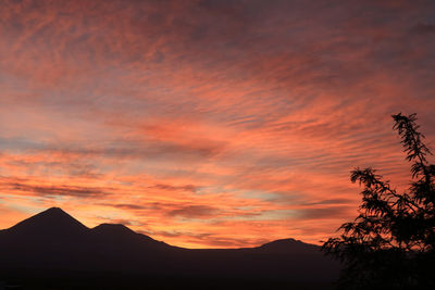 Scenic view of silhouette mountains against romantic sky at sunset