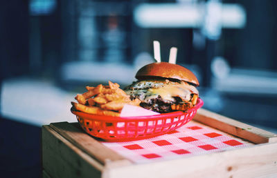 Close-up of hamburger and french fries served in basket on table