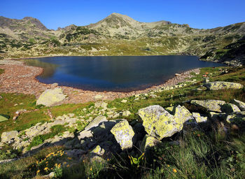 Scenic view of lake and mountains against clear sky