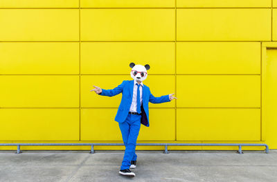 Full length of a man with yellow umbrella