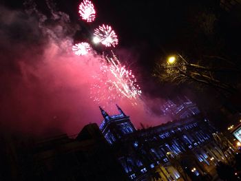 Low angle view of firework display at night