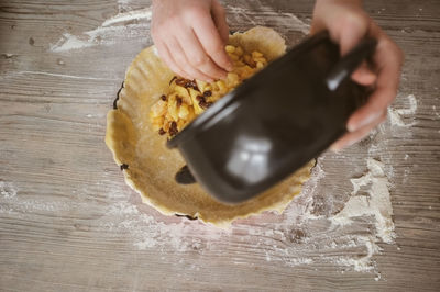 Cropped hand preparing tart at home