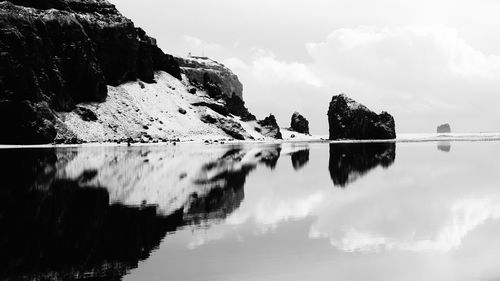 Reflection of mountains in lake against cloudy sky