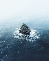 Aerial view of rock formation amidst sea