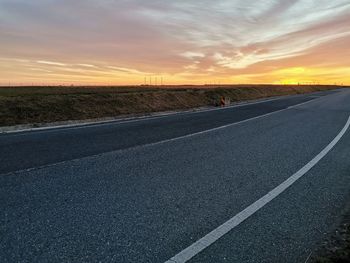 Surface level of road against sky during sunset