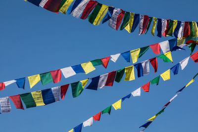 Low angle view of flags against blue sky