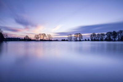 Scenic view of lake against sky at sunset