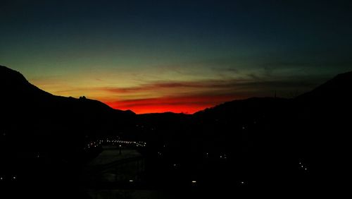 Scenic view of silhouette mountains against sky at sunset