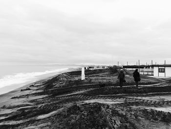 People standing on beach against sky