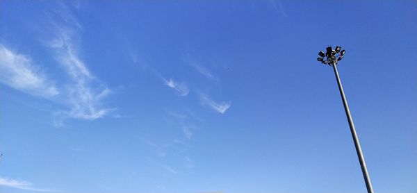 Low angle view of floodlight against blue sky