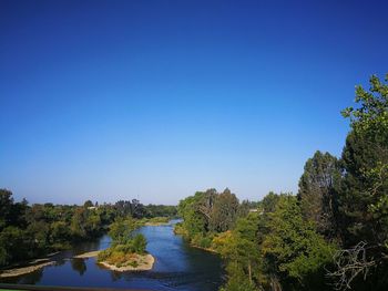 Scenic view of river against clear blue sky