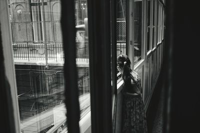 Girl looking through window in old building