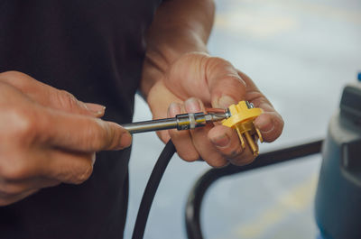 Midsection of man holding cable and socket