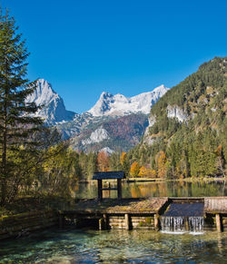 Scenic view of lake and mountains against blue sky