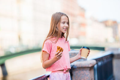 Midsection of woman holding ice cream standing outdoors