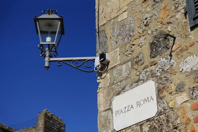 Low angle view of text on wall against building