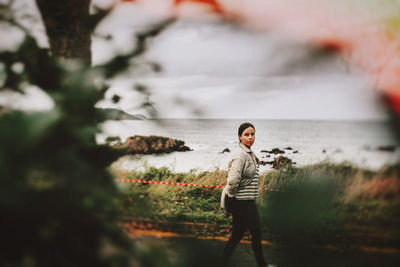 Rear view of woman standing against lake