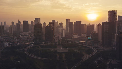 High angle view of city buildings against sky during sunset