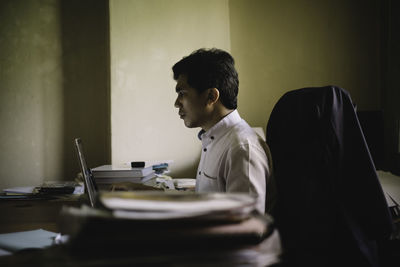 Side view of businessman working at desk in office