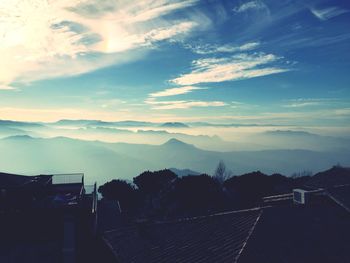 Scenic view of mountains in foggy weather against sky