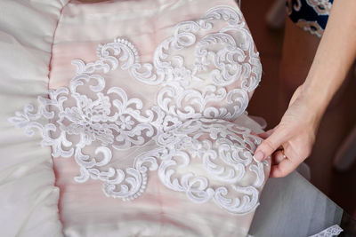 Cropped hands of woman holding white dress