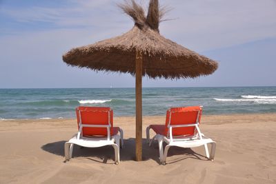 Lounge chairs under beach umbrella