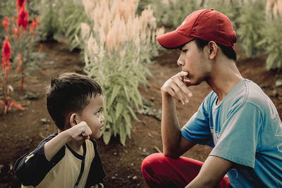 Cute little boy who argues with adults in the flower garden