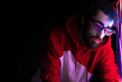 Young man wearing sunglasses against black background