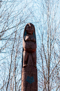 Low angle view of totem pole against bare trees