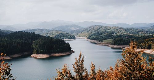 Scenic view of river and mountains against sky