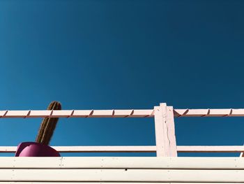 Low angle view of windmill on roof against clear blue sky