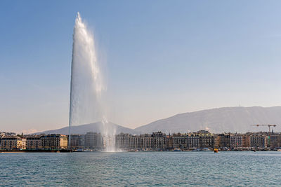 Beautiful view of the water jet fountain in the lake of geneva and the cityscape