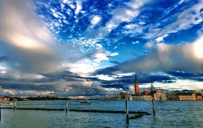 Buildings by sea against sky