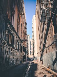 Road amidst buildings in city against clear sky