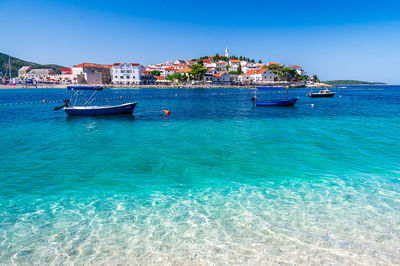 Boats in sea against clear sky