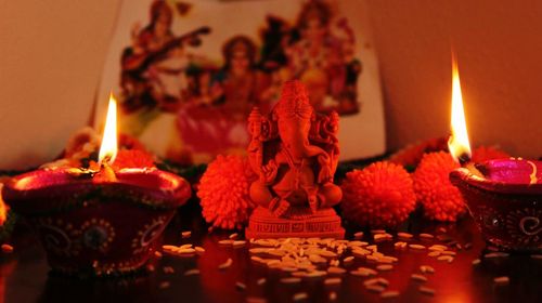 Lit diyas in front of ganesha idol